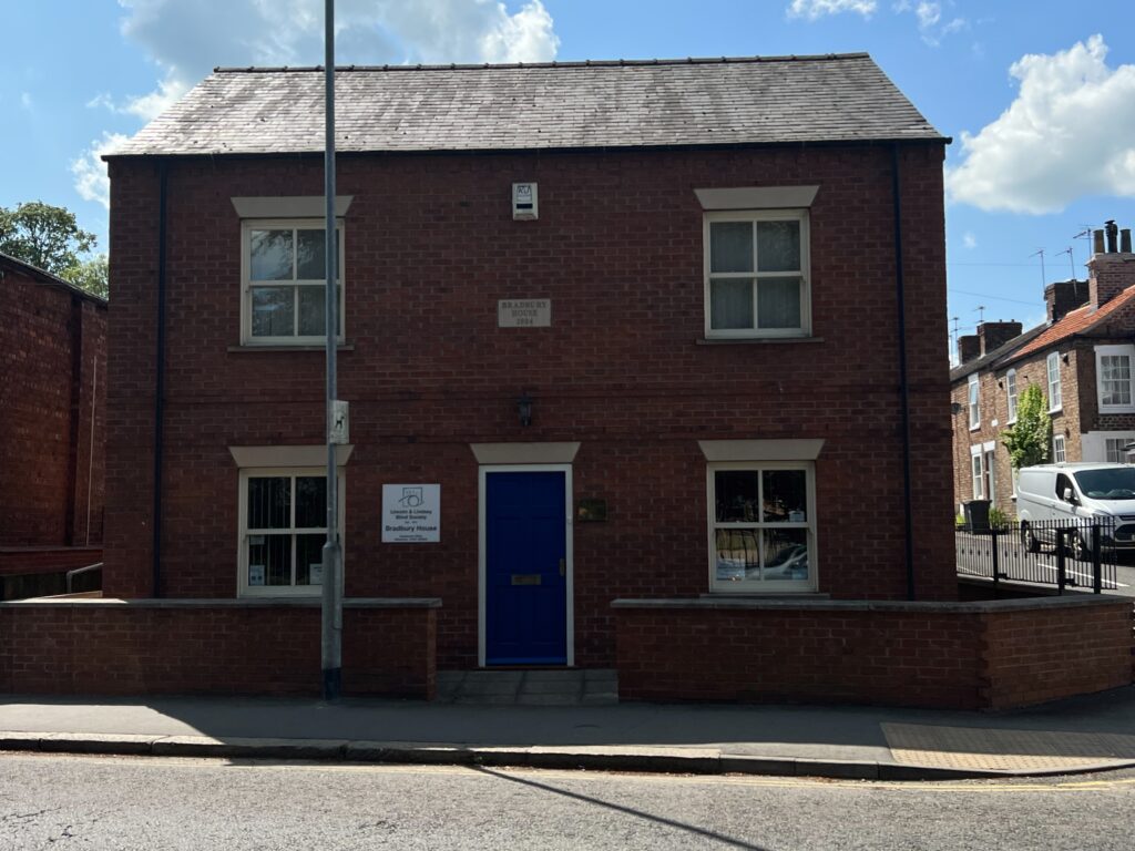 Bradbury House, a brick building with a blue door and four windows, two per floor. Head Office for Lincoln and Lindsey Blind Society